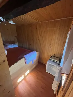 a small room with a bed in a cabin at Lisičja bajta in Stahovica