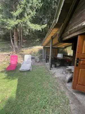 two chairs and a table next to a house at Lisičja bajta in Stahovica