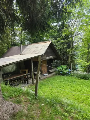 a building with a picnic table in the grass at Lisičja bajta in Stahovica
