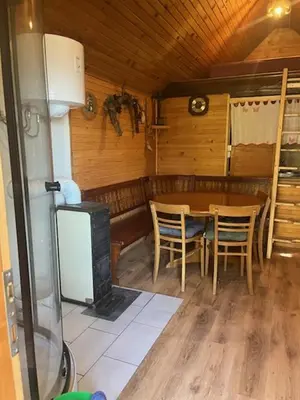 a dining room with a table and a stove at Lisičja bajta in Stahovica