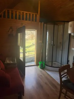 a living room with a sliding glass door and a couch at Lisičja bajta in Stahovica