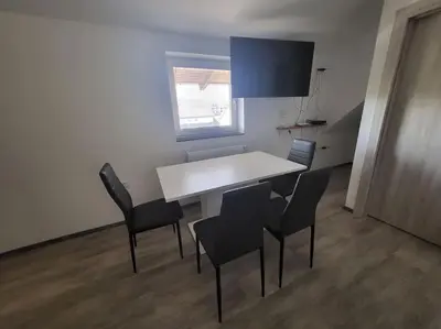a white table and chairs in a room with a window at Jack apartments in Maribor