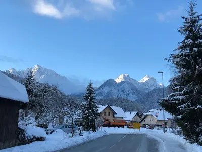 a snow covered village with mountains in the background at Apartment Maya in Kranjska Gora