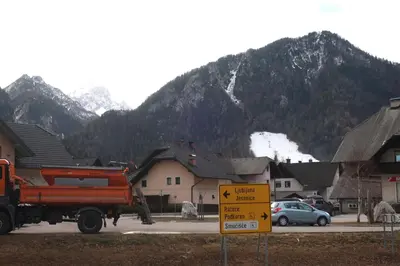 a truck parked in a parking lot with mountains in the background at Apartment Maya in Kranjska Gora
