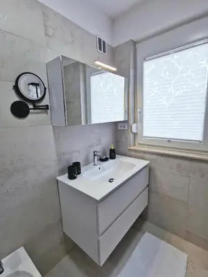 a white bathroom with a sink and a window at Dream home apartment in Koper