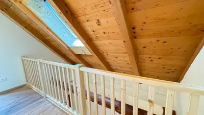 a white crib in a room with wooden ceilings at Juaniz in Tolmin