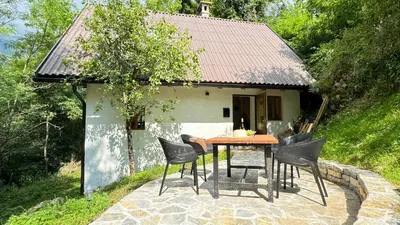 a table and chairs in front of a house at Juaniz in Tolmin