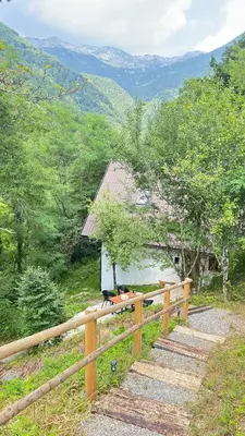 a wooden fence next to a house with a mountain at Juaniz in Tolmin