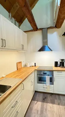 a kitchen with white cabinets and a stove top oven at Juaniz in Tolmin