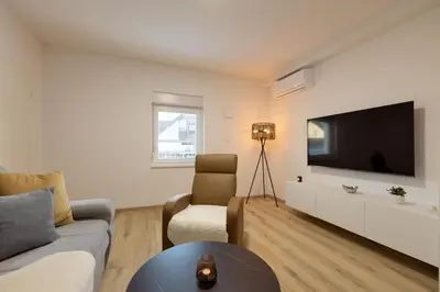 a living room with a couch and a tv at Apartments Lia in Ljubljana