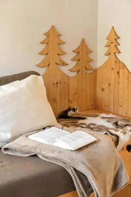 a book on a couch with trees on the wall at Chalet Vitranc in Kranjska Gora