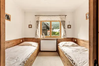 two beds in a room with a window at Chalet Vitranc in Kranjska Gora