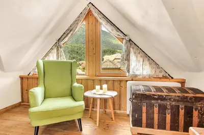 a green chair in a room with a window at Chalet Vitranc in Kranjska Gora