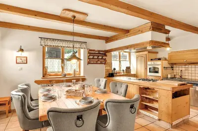 a kitchen with a wooden table and chairs at Chalet Vitranc in Kranjska Gora