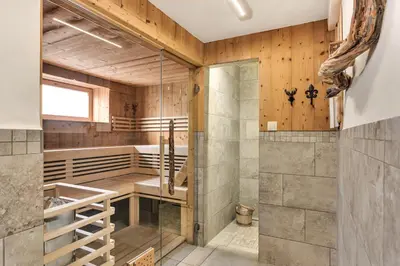 a sauna with wooden walls and a glass door at Chalet Vitranc in Kranjska Gora