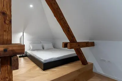 a small bed in a room with wooden beams at Villa Elizabeth - Family Apartment for 6 in Slovenj Gradec