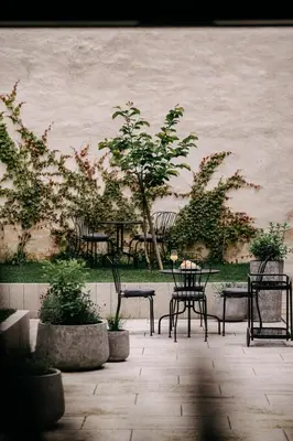 a patio with tables and chairs and trees at Villa Elizabeth - Family Apartment for 6 in Slovenj Gradec