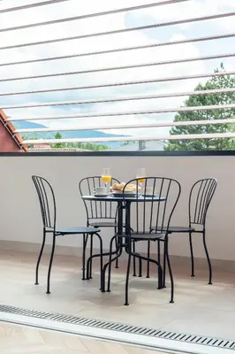 a table and chairs on a balcony with a window at Villa Elizabeth - Family Apartment for 6 in Slovenj Gradec