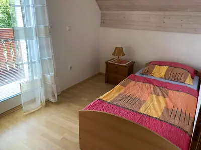 a bedroom with a bed and a dresser and a window at Apartmaji BOHINJ in Bohinj