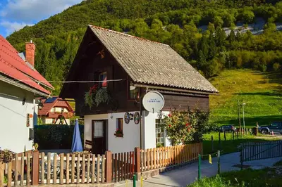 a small house with a fence in front of it at Apartmaji BOHINJ in Bohinj