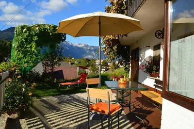 a patio with a table and an umbrella at Apartmaji BOHINJ in Bohinj