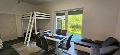 a living room with a dining table and a bunk bed at Apartma Marija in Kranjska Gora
