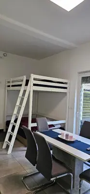 a bedroom with a bunk bed and a table and chairs at Apartma Marija in Kranjska Gora