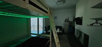 a room with a bunk bed with a ladder at Apartma Marija in Kranjska Gora