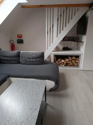 a living room with a couch and a staircase at Apartment Loft Pejić - open space loft studio near Bovec, Soča Valley in Bovec