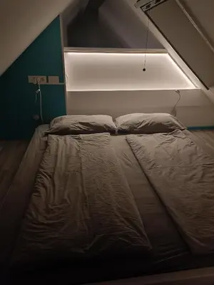 a bed in a room with a light above it at Apartment Loft Pejić - open space loft studio near Bovec, Soča Valley in Bovec