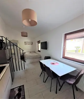 a living room with a table and chairs and a bed at Studio Sofia in Rakek