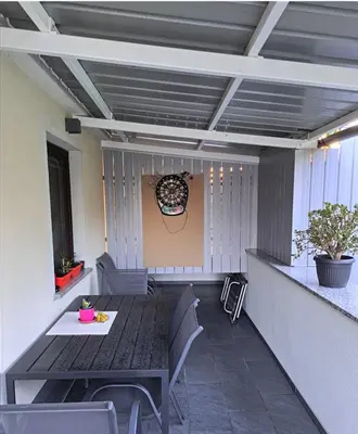 a patio with a table and chairs in a room at Studio Sofia in Rakek