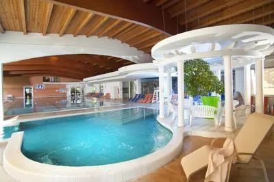a large swimming pool in a building with a pool at Lux Chalet - Sauna and Hot Tub in Topolšica