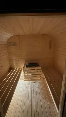 a large wooden sauna with a bed in the middle at Lux Chalet - Sauna and Hot Tub in Topolšica