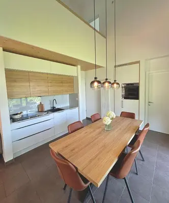 a dining room with a wooden table and chairs at Lux Chalet - Sauna and Hot Tub in Topolšica