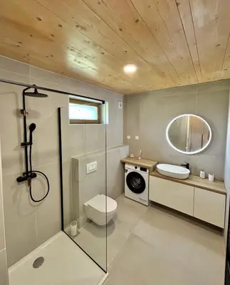 a bathroom with a shower and a toilet and a sink at Lux Chalet - Sauna and Hot Tub in Topolšica