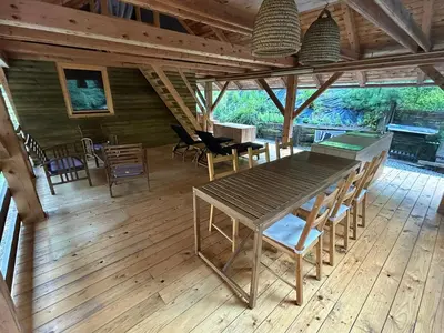 a dining room with a table and chairs on a wooden floor at The BeeHouse, Nature stay in Šempeter v Savinjski Dolini