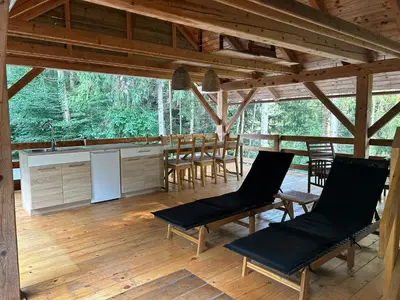a kitchen and dining room of a cabin with wooden floors at The BeeHouse, Nature stay in Šempeter v Savinjski Dolini