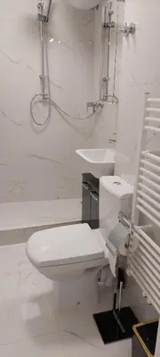 a white bathroom with a toilet and a sink at URBAN HARMONY APARTMENT Maribor in Maribor