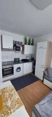 a kitchen with white cabinets and a refrigerator at URBAN HARMONY APARTMENT Maribor in Maribor