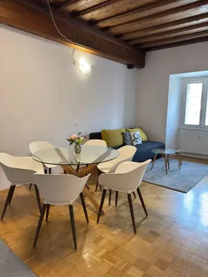 a dining room with a table and chairs and a couch at Ljubljana Center Apartments in Ljubljana