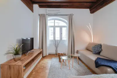 a living room with a couch and a tv at Ljubljana Center Apartments in Ljubljana