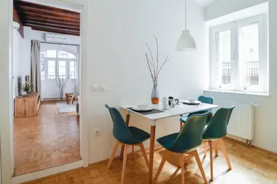 a dining room with a table and green chairs at Ljubljana Center Apartments in Ljubljana