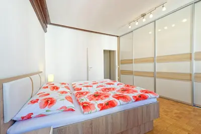 a bedroom with a bed with red flowers on it at Ljubljana Center Apartments in Ljubljana