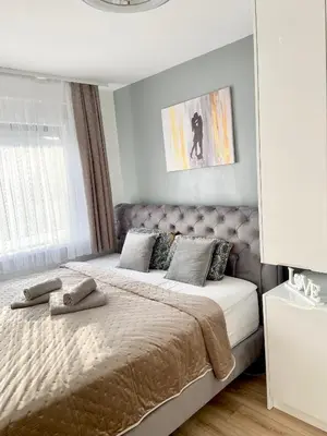 a bedroom with a large bed with a headboard at Black & White Hideaway with garage in Ljubljana