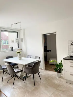 a kitchen and dining room with a white table and chairs at Black & White Hideaway with garage in Ljubljana