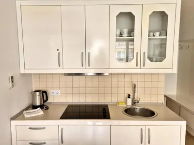 a kitchen with white cabinets and a sink at Apartmaji PANONIA 