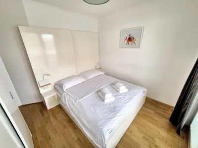 a small bedroom with a white bed with two pillows at Apartmaji PANONIA 