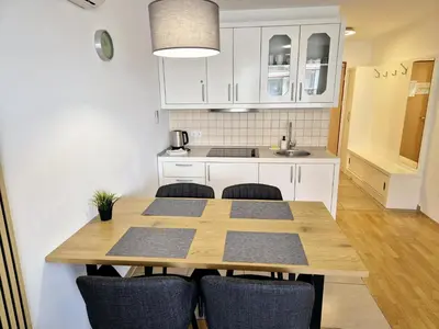 a kitchen with a wooden table and chairs at Apartmaji PANONIA 