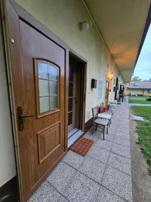 a door to a building with a child sitting on a bench at Neptun apartment in Ljubljana